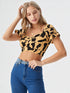Woman wearing yellow and black cow print puff sleeve ruched crop top
