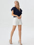 Woman wearing navy blue ruffle sleeve V-neck top with white shorts