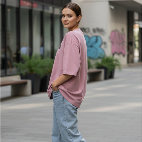 Mauve cotton oversized t-shirt with a small minimal chest logo worn by a woman