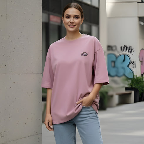 Mauve cotton oversized t-shirt with a small minimal chest logo worn by a woman