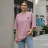 Mauve cotton oversized t-shirt with a small minimal chest logo worn by a woman