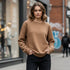 Brown minimal crewneck sweatshirt worn by a woman in a street setting