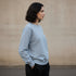 Light blue minimal crewneck sweatshirt worn by a woman