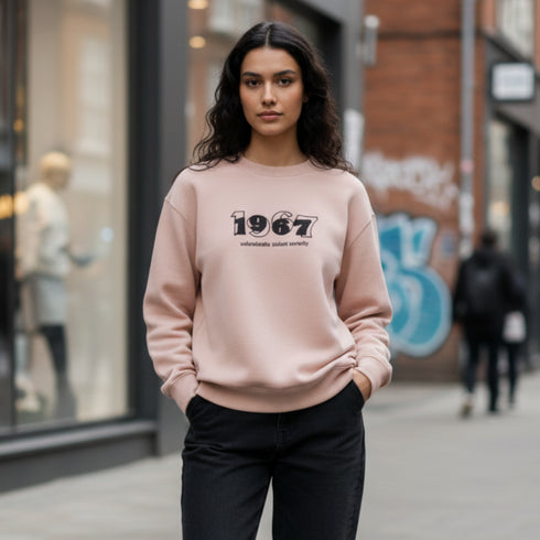 Beige crewneck sweatshirt with a 1967 front graphic worn by a woman