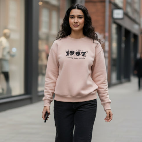 Beige crewneck sweatshirt with a 1967 front graphic worn by a woman
