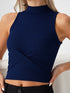 Close-up of woman wearing navy blue mock neck sleeveless ribbed top with crossover waist design