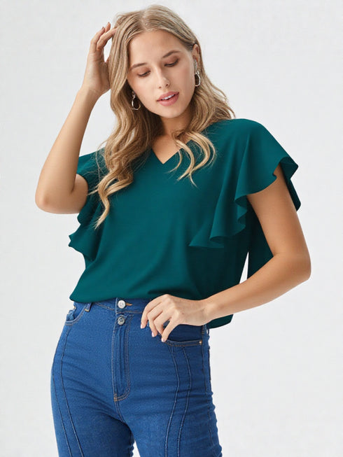 Woman wearing a green ruffle sleeve v-neck top paired with denim jeans