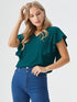 Woman wearing a green ruffle sleeve v-neck top paired with denim jeans