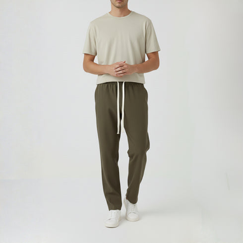 Man wearing olive green baggy fit cotton trousers with white t-shirt