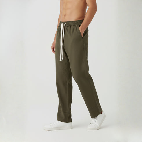 Man wearing olive green baggy fit cotton trousers with white t-shirt