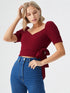Woman wearing a wine red puff sleeve wrap top with tie waist