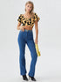 Woman wearing yellow and black cow print puff sleeve ruched crop top