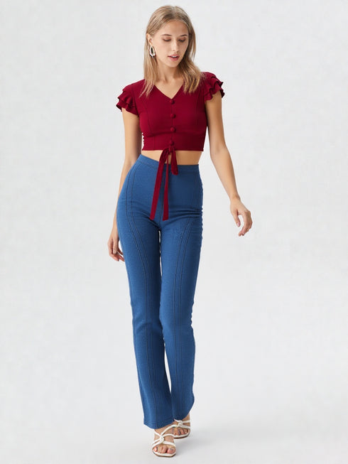 Woman wearing a red ruffle sleeve tie-front crop top with buttons