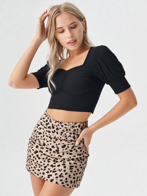 Close-up of woman wearing black sweetheart neck puff sleeve crop top with printed skirt