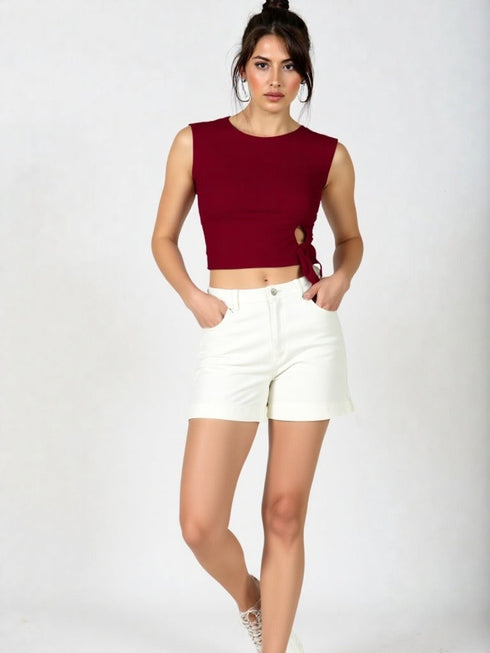 Woman wearing wine red side tie sleeveless crop top with white high-waisted trousers