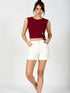 Woman wearing wine red side tie sleeveless crop top with white high-waisted trousers