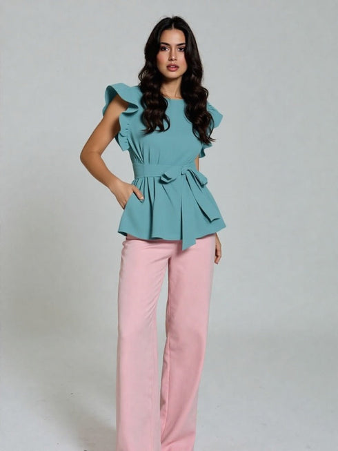 Woman wearing sea green ruffle sleeve belted peplum top with black trousers