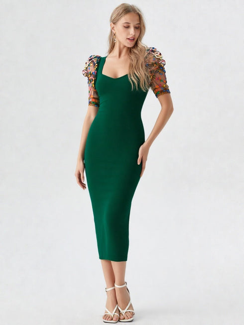 Woman wearing a green bodycon midi dress with embroidered puff mesh sleeves