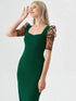 Woman wearing a green bodycon midi dress with embroidered puff mesh sleeves