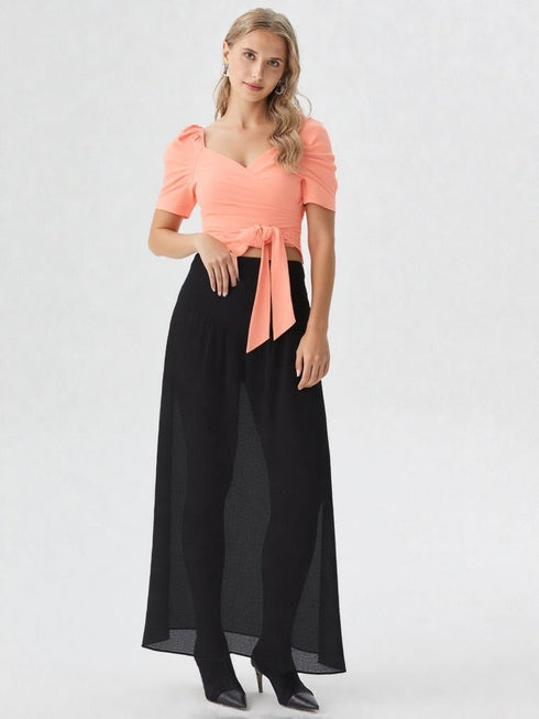 Woman wearing a peach puff sleeve wrap top with tie waist