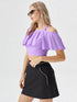 Woman wearing lavender one shoulder ruffle crop top with black skirt