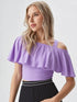 Woman wearing lavender one shoulder ruffle crop top with black skirt