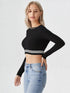 Woman wearing black mock neck long sleeve crop top with striped hem paired with blue jeans