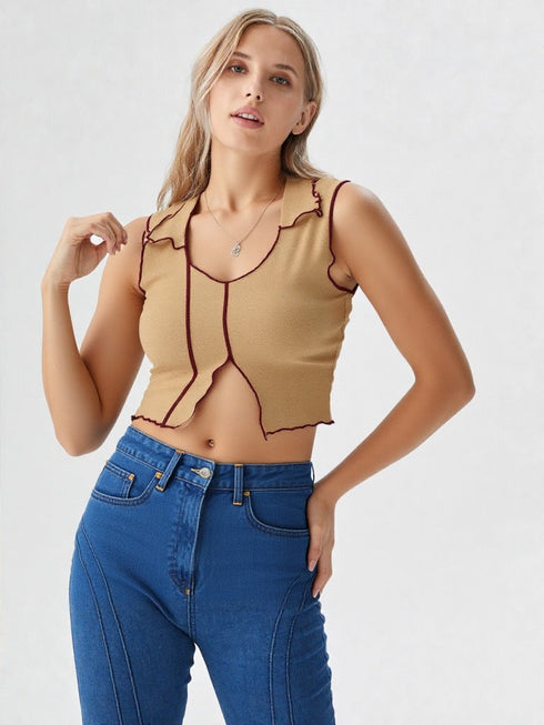 Woman wearing camel contrast stitch sleeveless crop top with wavy hem and blue jeans