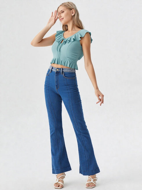 Woman wearing sea green ruffle trim tie front crop top with high-waisted jeans