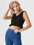Woman wearing a black ruffle tie-front crop top with peplum hem and blue jeans
