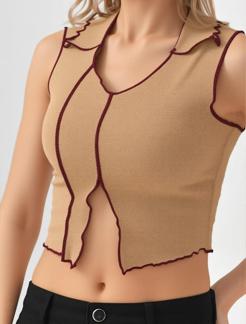 Woman wearing camel contrast stitch sleeveless crop top with wavy hem and blue jeans