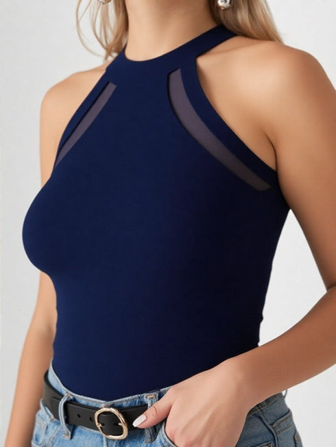 Close-up of woman wearing navy blue halter neck cutout top with black belt and denim jeans