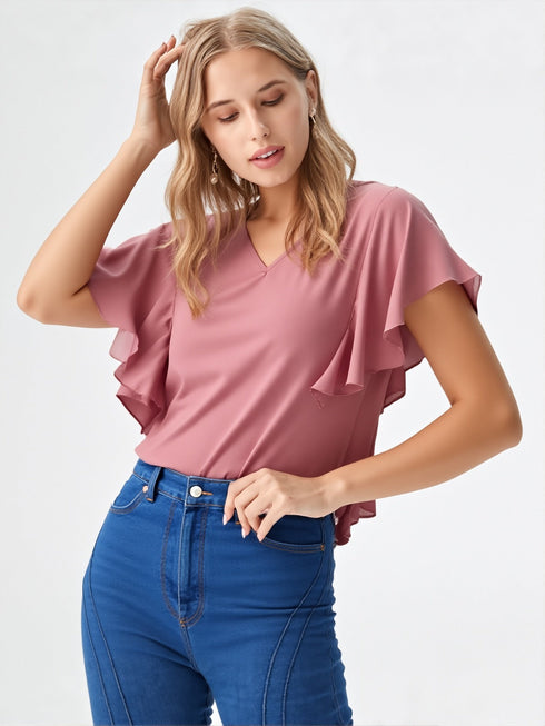 Woman wearing rose pink flutter sleeve V-neck polyester top styled with blue jeans