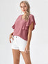 Woman wearing rose pink flutter sleeve V-neck polyester top styled with blue jeans
