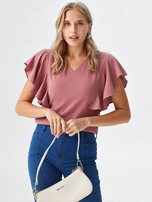 Woman wearing rose pink flutter sleeve V-neck polyester top styled with blue jeans