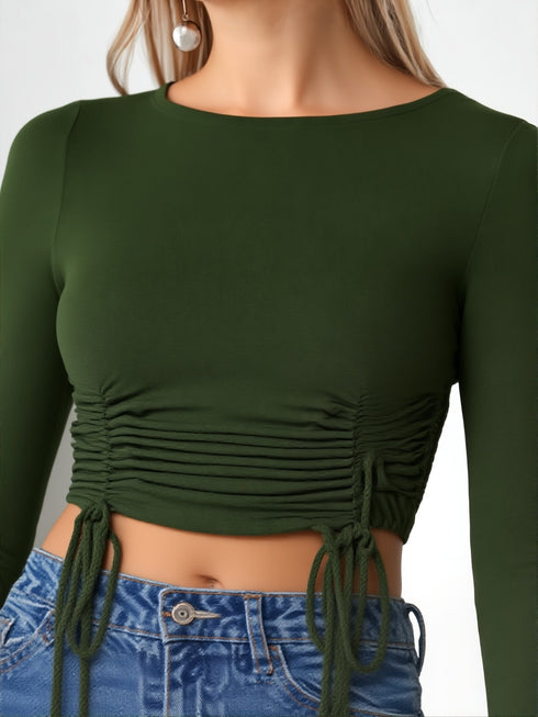 Woman wearing a dark green ruched drawstring long sleeve crop top