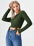 Woman wearing a dark green ruched drawstring long sleeve crop top