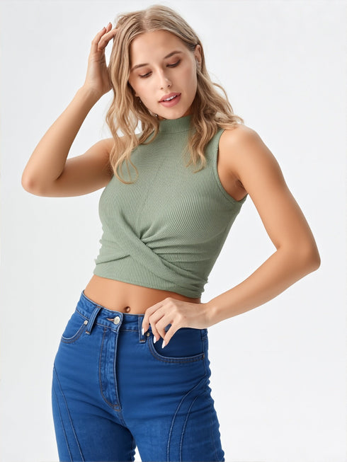 Woman wearing green sleeveless ribbed wrap crop top with high-waisted jeans