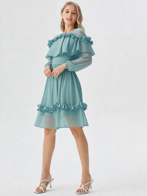 Woman wearing teal ruffle off shoulder long sleeve dress with layered detailing and white heels
