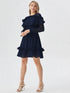 Woman wearing navy blue ruffle layer long sleeve dress with flowy hem
