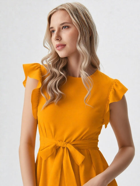 Woman wearing mustard yellow ruffle sleeve belted top with blue jeans