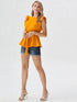 Woman wearing mustard yellow ruffle sleeve belted top with blue jeans