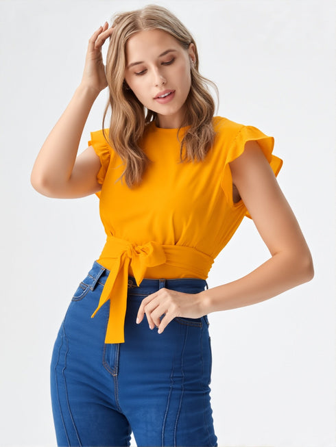 Woman wearing mustard yellow ruffle sleeve belted top with blue jeans
