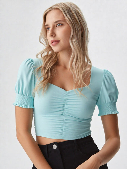 Woman wearing a sky blue ruched square neck puff sleeve crop top