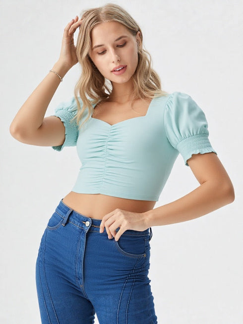 Woman wearing a sky blue ruched square neck puff sleeve crop top