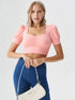 Woman wearing a peach ruched square neck puff sleeve crop top