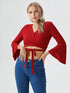 Woman wearing a red flared sleeve wrap crop top with tie detail