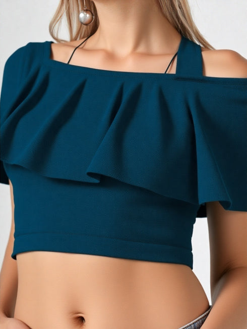 Woman wearing teal one-shoulder ruffle crop top with belted jeans