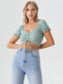 Woman wearing mint green ruched drawstring puff sleeve crop top with denim shorts