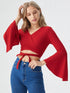 Woman wearing a red flared sleeve wrap crop top with tie detail